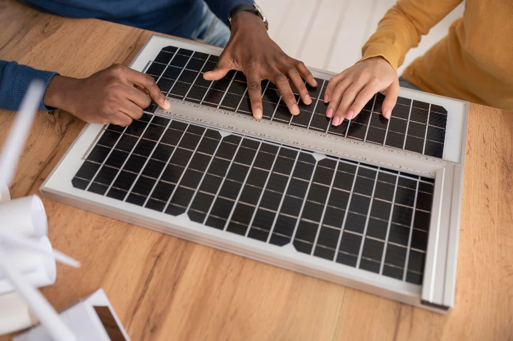 Deux mains sur un panneau solaire symbolisant la production d'un panneau solaire